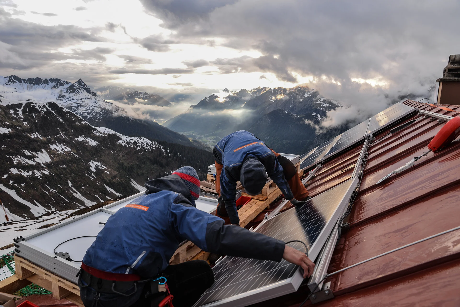 Zwei Männer reparieren das Dach einer Berghütte | © DAV / Se. Reutlingen Erl GmbH